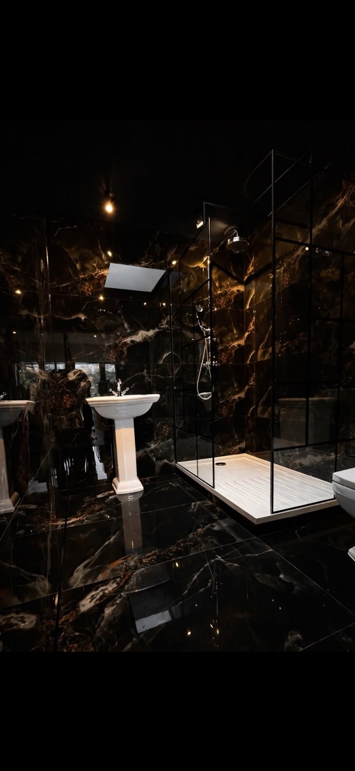 Completed black tiled bathroom with walk-in shower