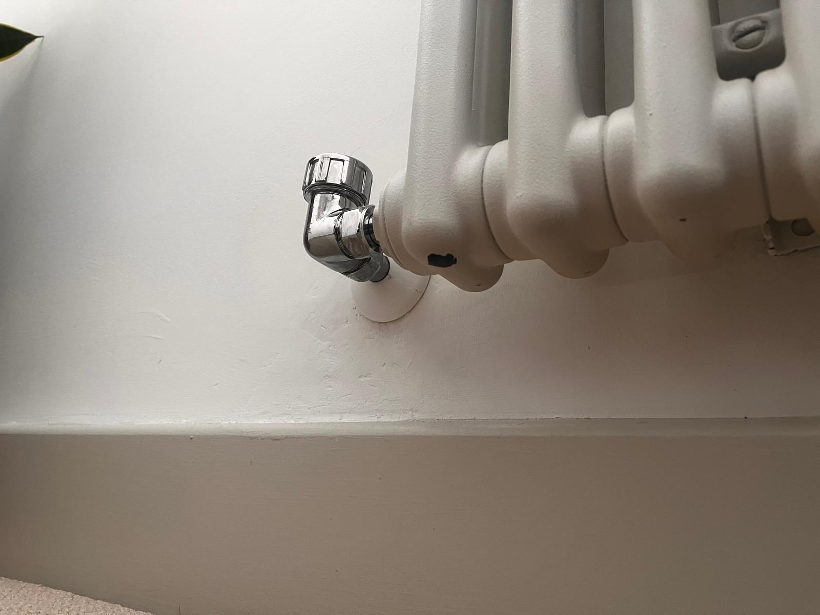 Close-up of neat radiator valve and pipework